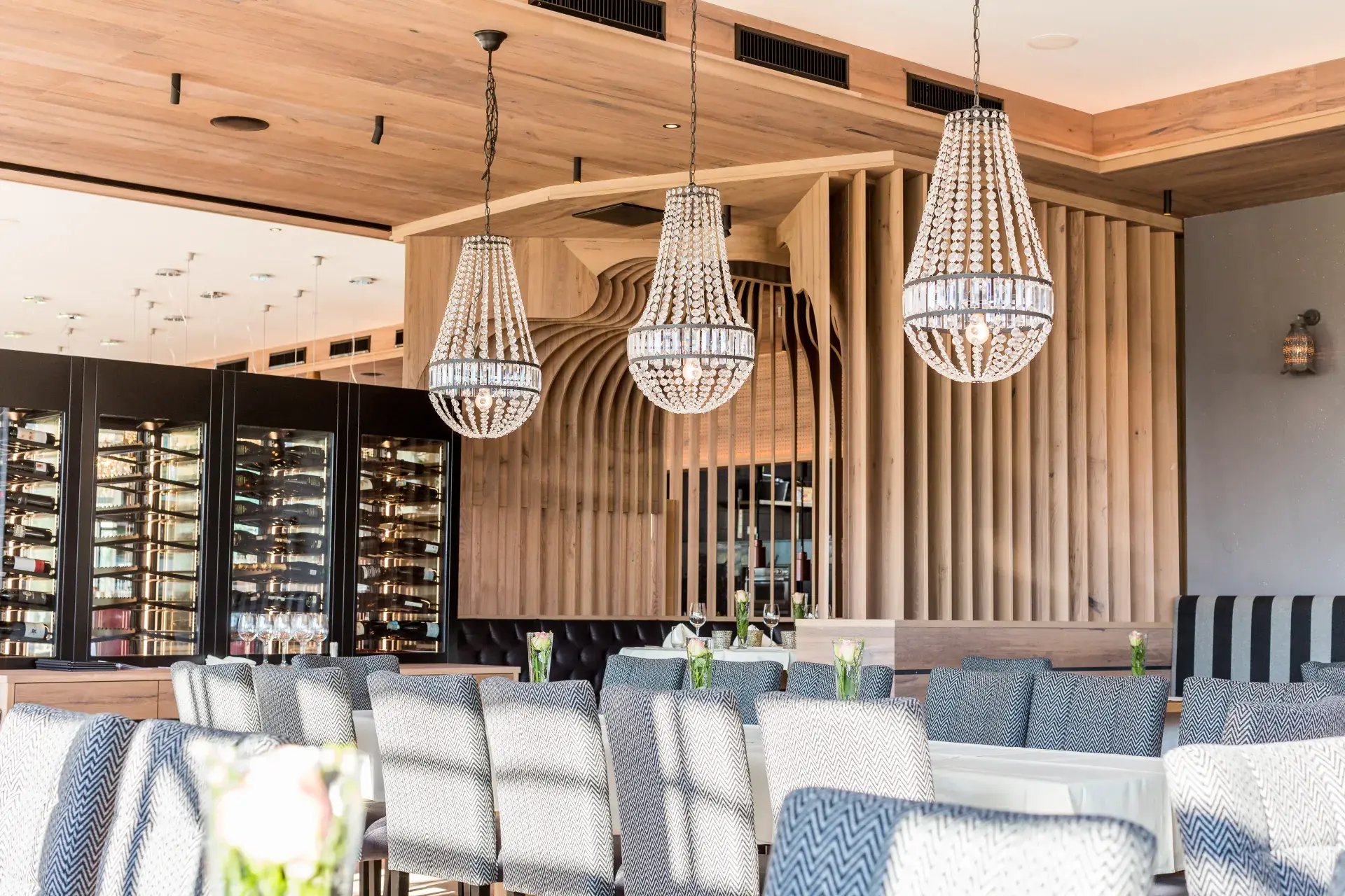 Woven pendant lamps above set tables in the Greenvieh Greenside restaurant, Mieming Tyrol