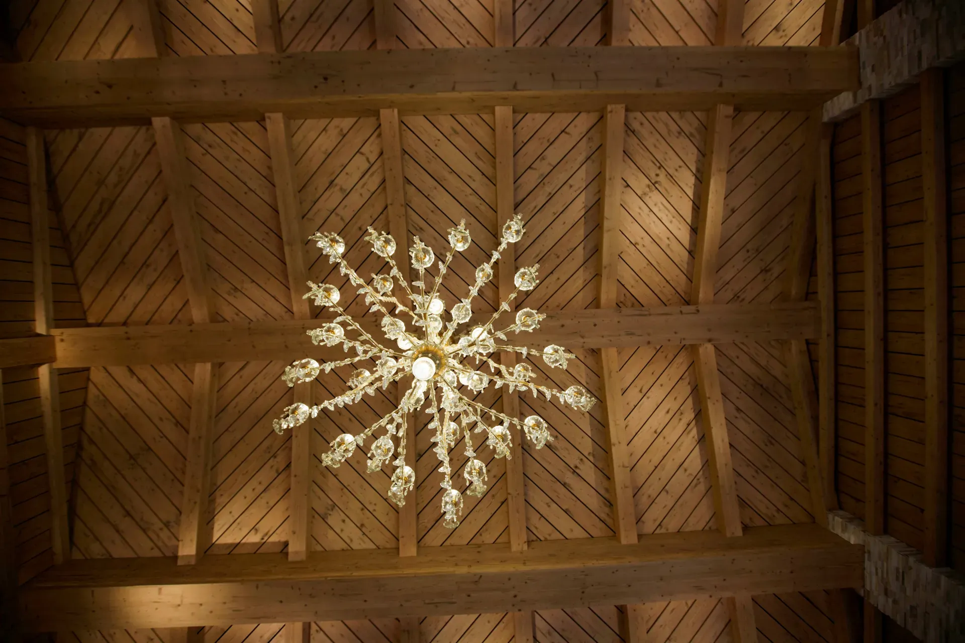 Crystal chandelier on the wooden ceiling of the Greenvieh Chalet in Tyrol