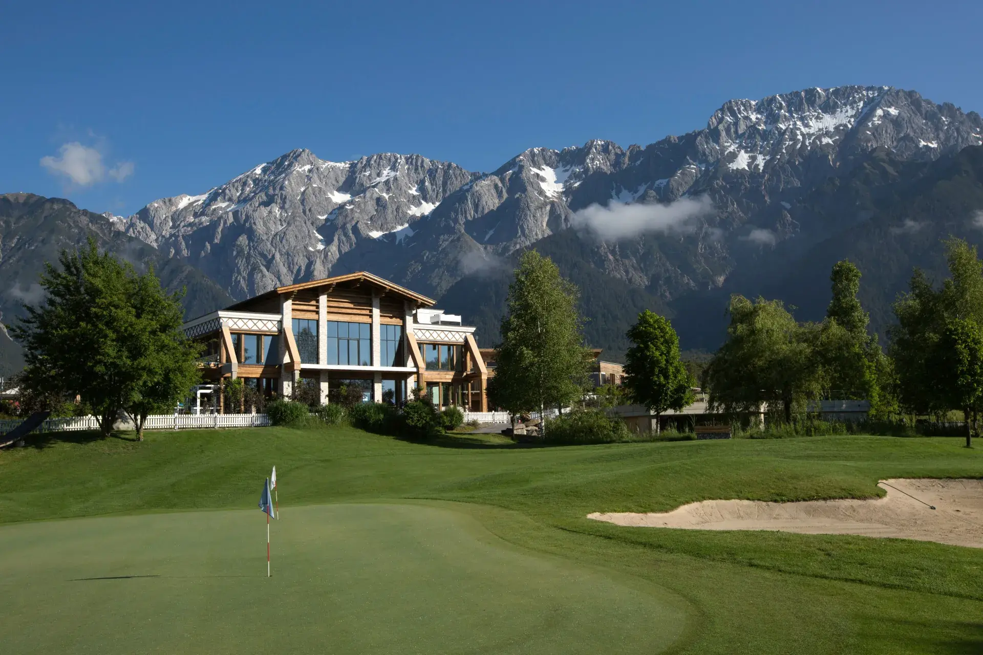 Greenvieh Chalet above the green golf lawn against the Mieming mountains in Tyrol