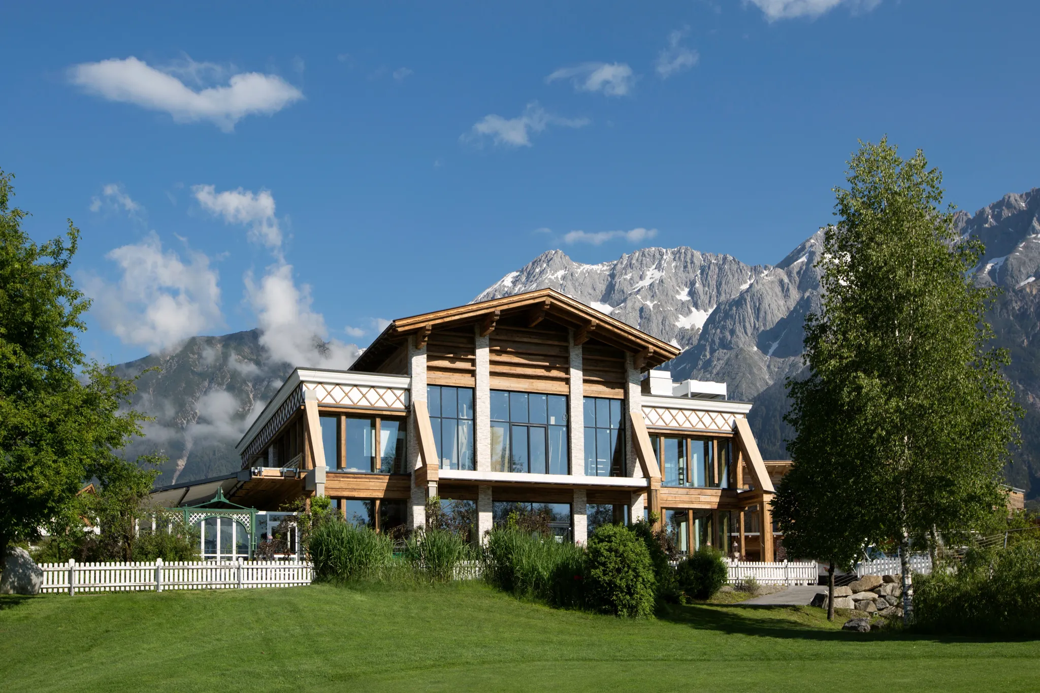 Exterior of the Greenvieh restaurant and chalet against the mountains on the Mieming sun plateau
