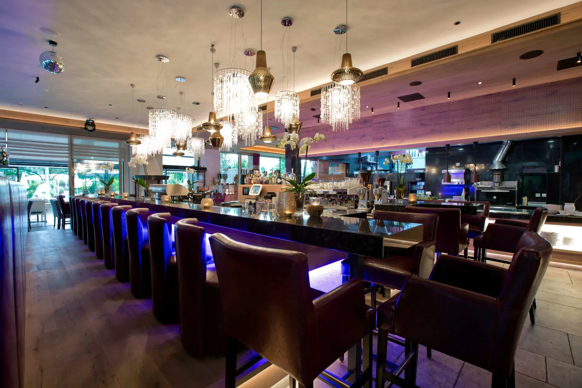 Bar at the Greenvieh restaurant with bar stools and warm lighting in Mieming, Tyrol
